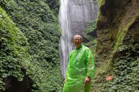 Tourist in fetching green at the Madakaripura Waterfall