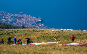 Preparing paragliders on western side of Monte Baldo, with goats, Malcesine in background