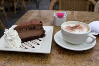 Large cappuccino and enormous slice of cheesecake at The Cheesecake Factory